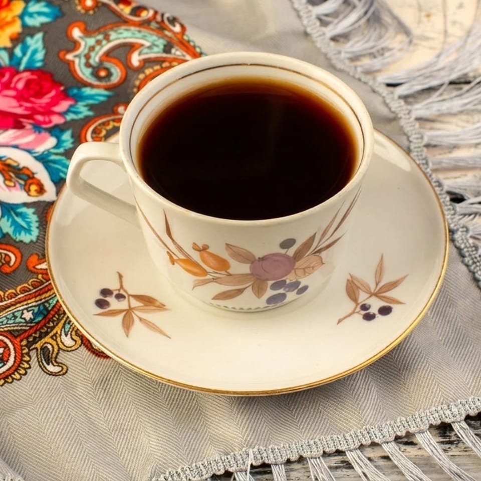 Dark coffee on a floral saucer